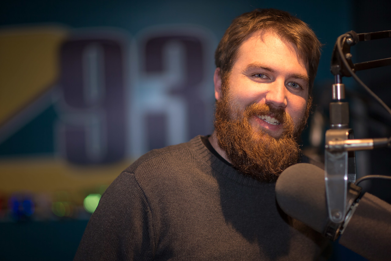 Local radio host Jesse standing behind microphone