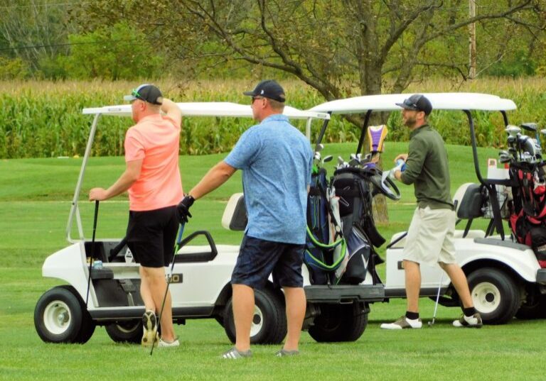 a group of men carrying golf clubs
